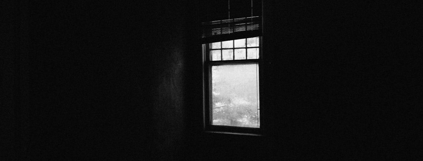 A darkened room with a window showing the night sky