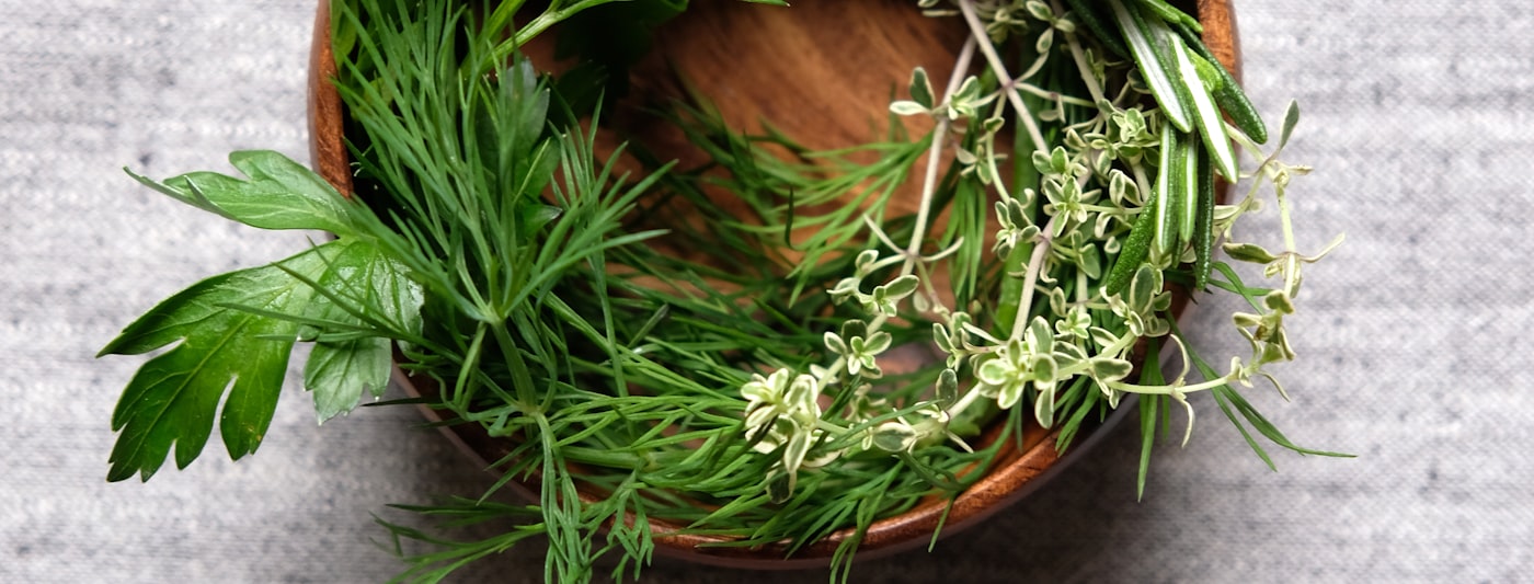 A wooden bowl of dried botanical herbs